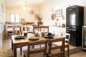 Una cocina con muebles de madera, un refrigerador negro y diversos utensilios de cocina sobre la encimera.