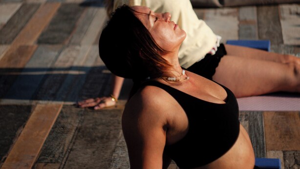 A person performing a yoga pose on a blue mat.
