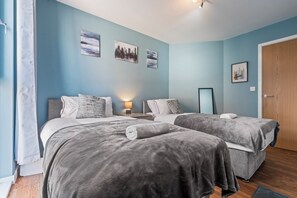 A hotel room with two beds, a wooden door, and cityscape artwork on the walls. - Luxury Birmingham City Centre Stay + Free Parking (Birmingham)