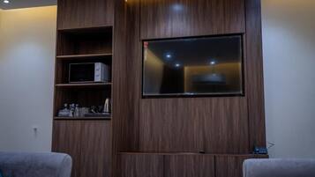 Un salón moderno con televisor empotrado, estanterías de madera y televisor de pantalla plana montado en la pared.