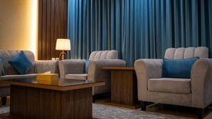 Una habitación de hotel con un conjunto de sofá, una mesa de centro y una lámpara.