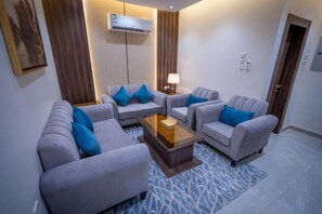 A modern living room with two sofas, a coffee table, and a lamp.