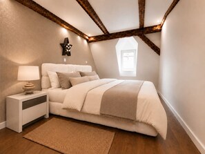 A bedroom with a bed, nightstand, lamp, star-shaped wall decoration, and a window. - Old Prague Charm | Historic 2BR by Charles Bridge (Prague 1)