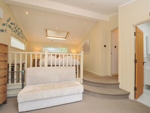 A staircase leading to a bedroom with a crib, a wooden cabinet, and a wall with fish decorations. - 5 Tree Tops (Looe)