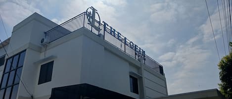 A modern building with a prominent balcony and a sign that reads 'ELLE'.
