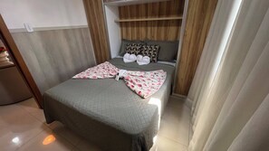 A neatly made bed with a quilted cover, pillows, and a blanket folded on top. - Apto 201 Flat Prático Perto de Tudo (Belém)