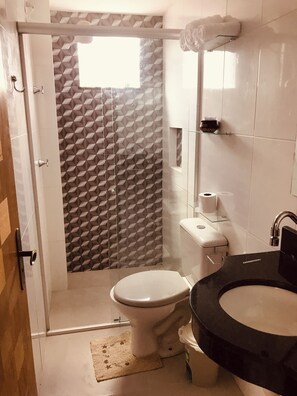 A bathroom with a toilet, sink, and shower area. - Apto 201 Flat Prático Perto de Tudo (Belém)