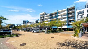 A multi-story parking structure with a covered walkway and a landscaped area with trees. - The Terraces 220 (Cape Town)