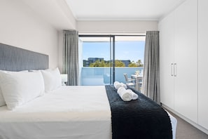Ein modernes Hotelzimmer mit einem großen Bett, einem Balkon und Blick auf die Stadt.