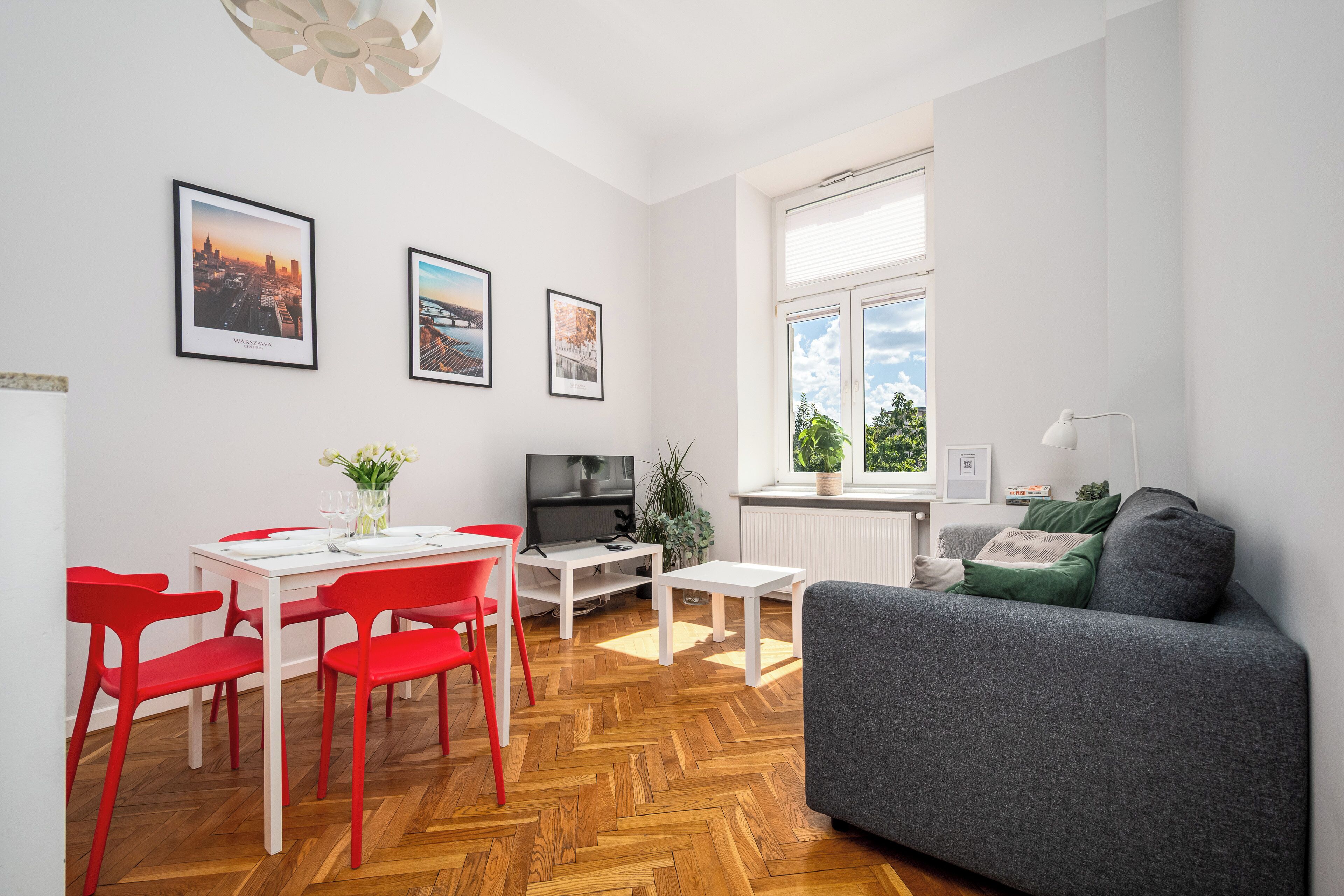 A modern living space with a dining area, a sofa, and a TV.