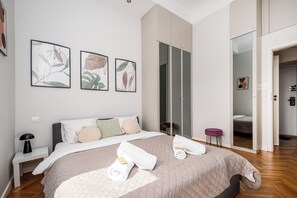 Un dormitorio moderno con una cama grande, un armario y una obra de arte en la pared.