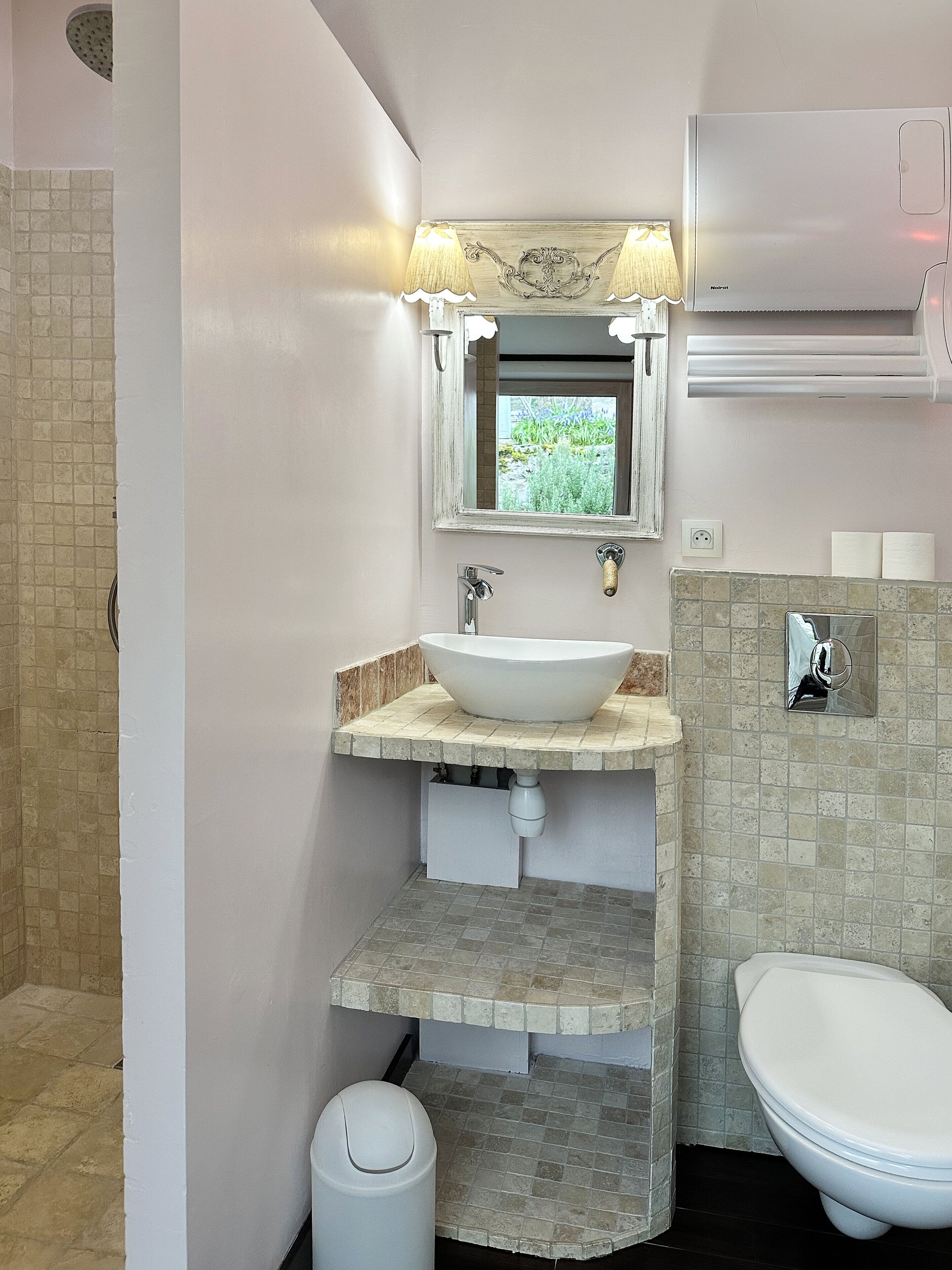 Ein Badezimmer mit Waschbecken, Spiegel und Toilette.