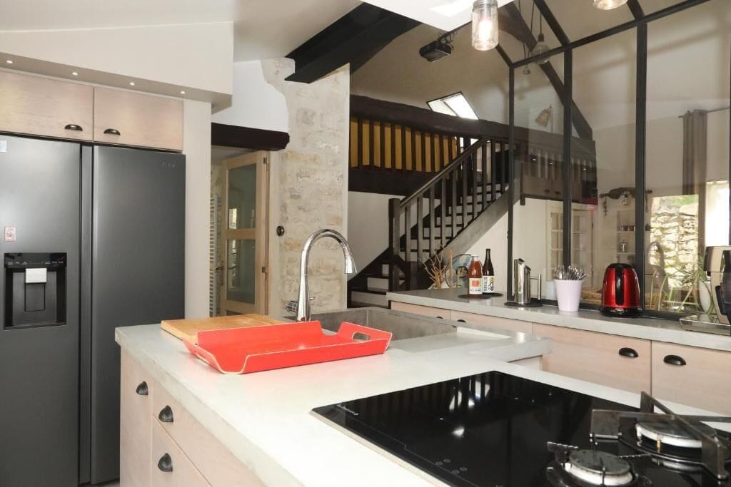 A modern kitchen with a built-in stove, a refrigerator, and a sink.