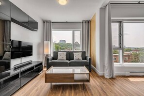 Ein modernes Wohnzimmer mit Flachbildfernseher, einer Couch und einem Couchtisch.