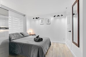 Ein Schlafzimmer mit einem Bett, einem Nachttisch, einer Lampe und zwei Wandleuchten.