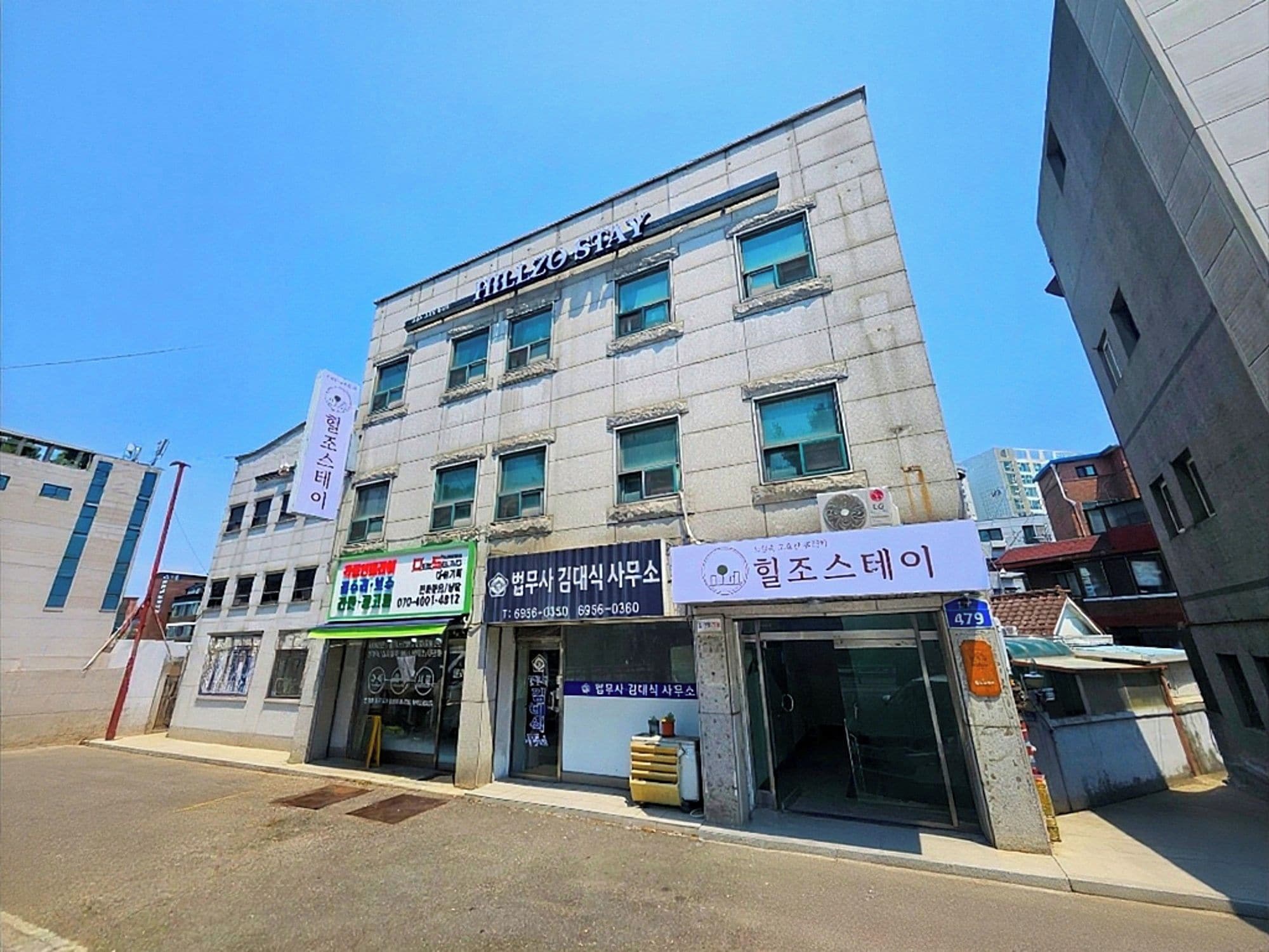 A multi-story building with signage for a hotel and various businesses.