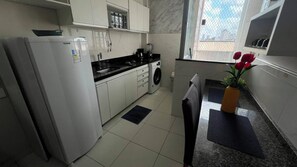 A compact kitchen with a refrigerator, a coffee maker, and a sink. - Apto 303 2 Qtos 15 min do Centro (Belém)