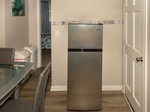 A kitchen with a stainless steel refrigerator, a glass table, and a microwave. - Pine View Corner - GA (Riverdale)