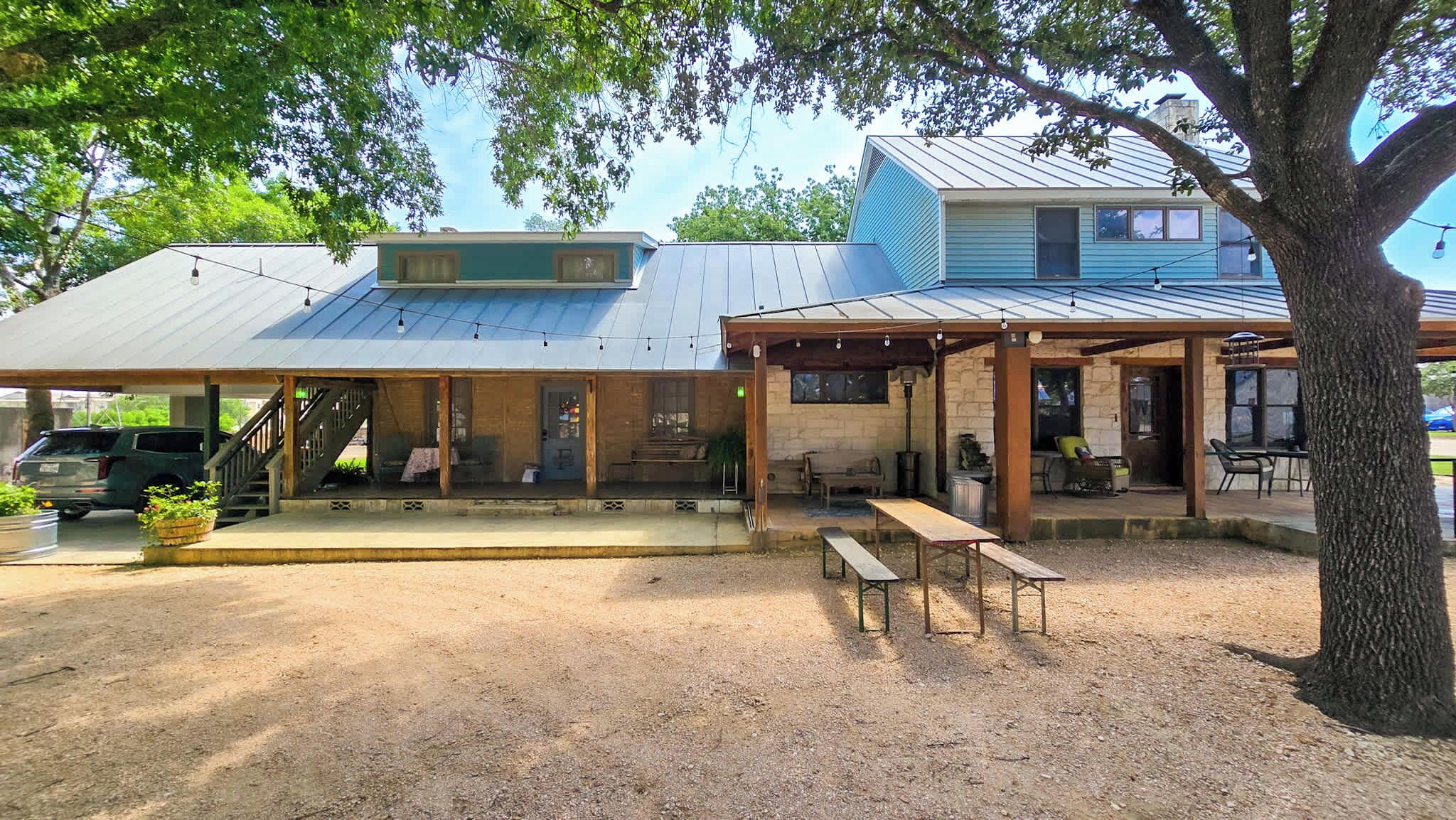 Un bâtiment doté d’un patio couvert, d’un espace extérieur aménagé pour s’asseoir et d’un sol en terre battue.