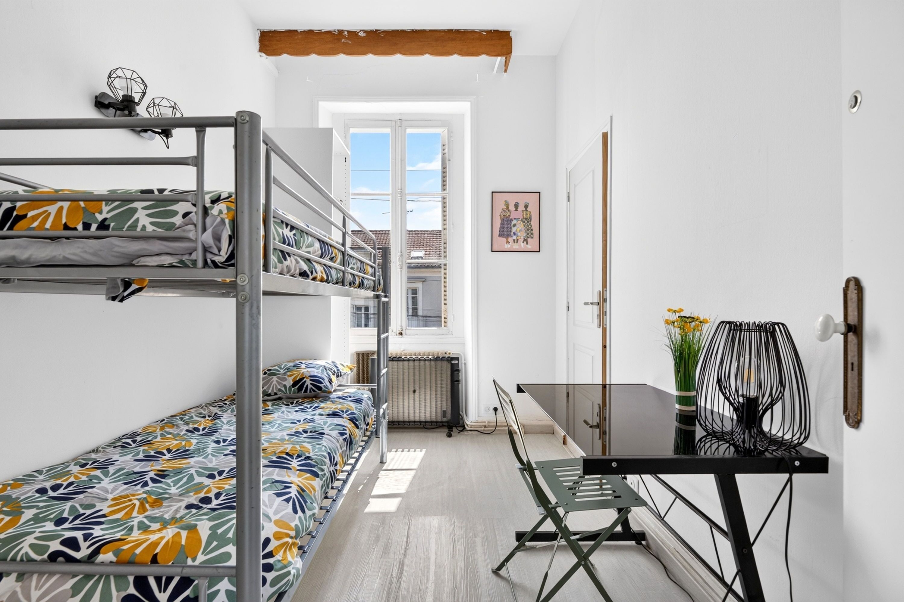 Ein Schlafsaalzimmer mit Etagenbetten, einem Schreibtisch und einem Stuhl.