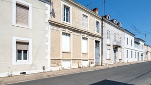 Filera d'edificis europeus tradicionals amb façanes idèntiques, cel blau i carrer tranquil.