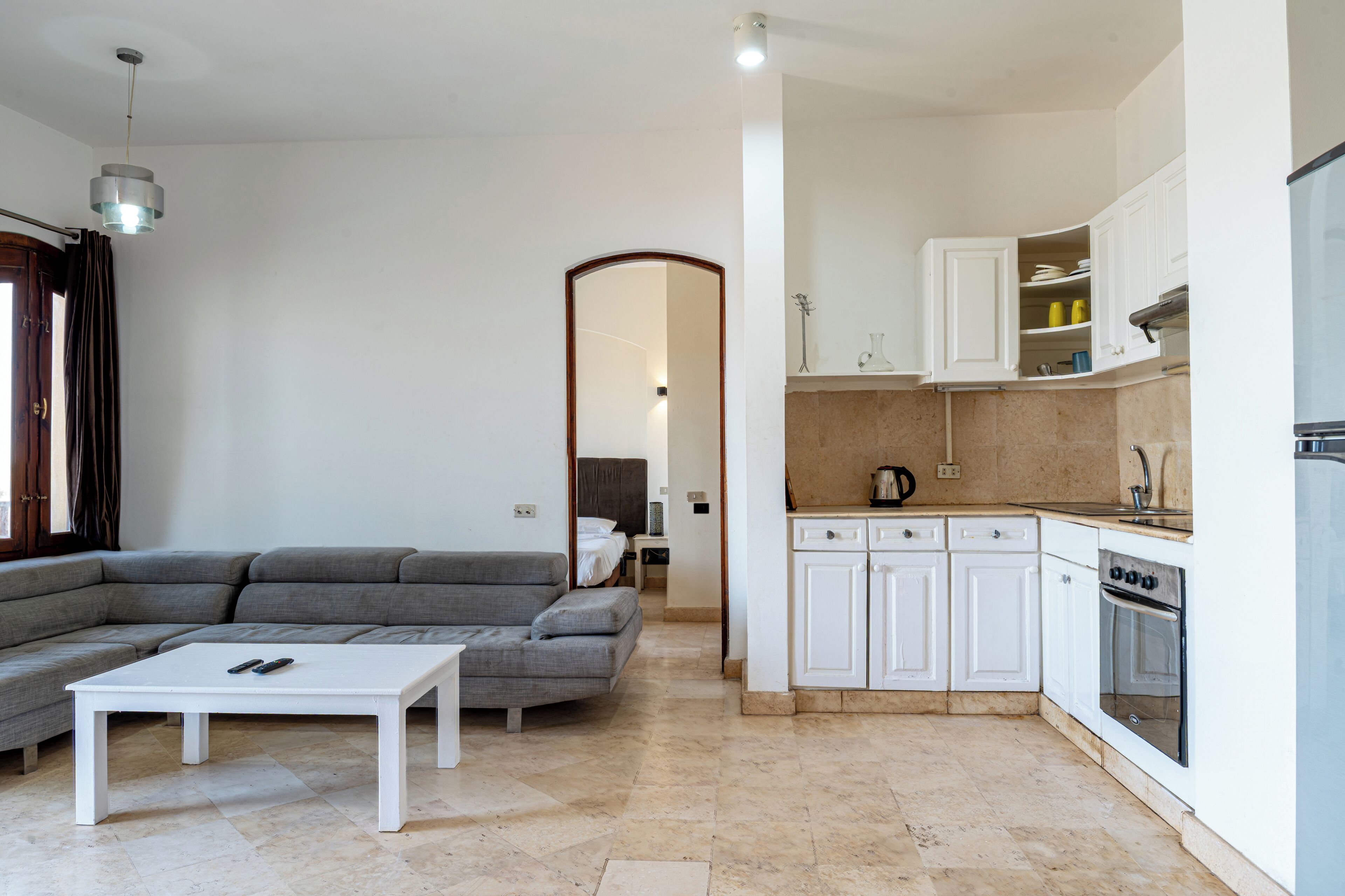 A modern kitchen with white cabinets, a stove, and a sink.