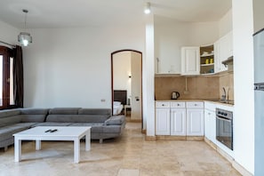 Una cocina moderna con armarios blancos, una estufa y un lavamanos.