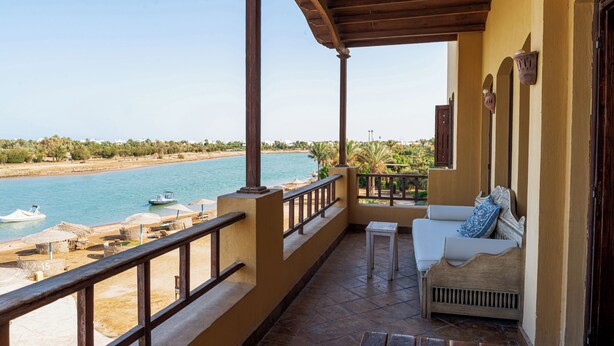 Un balcone con vista sul mare, un divano e un tavolino.