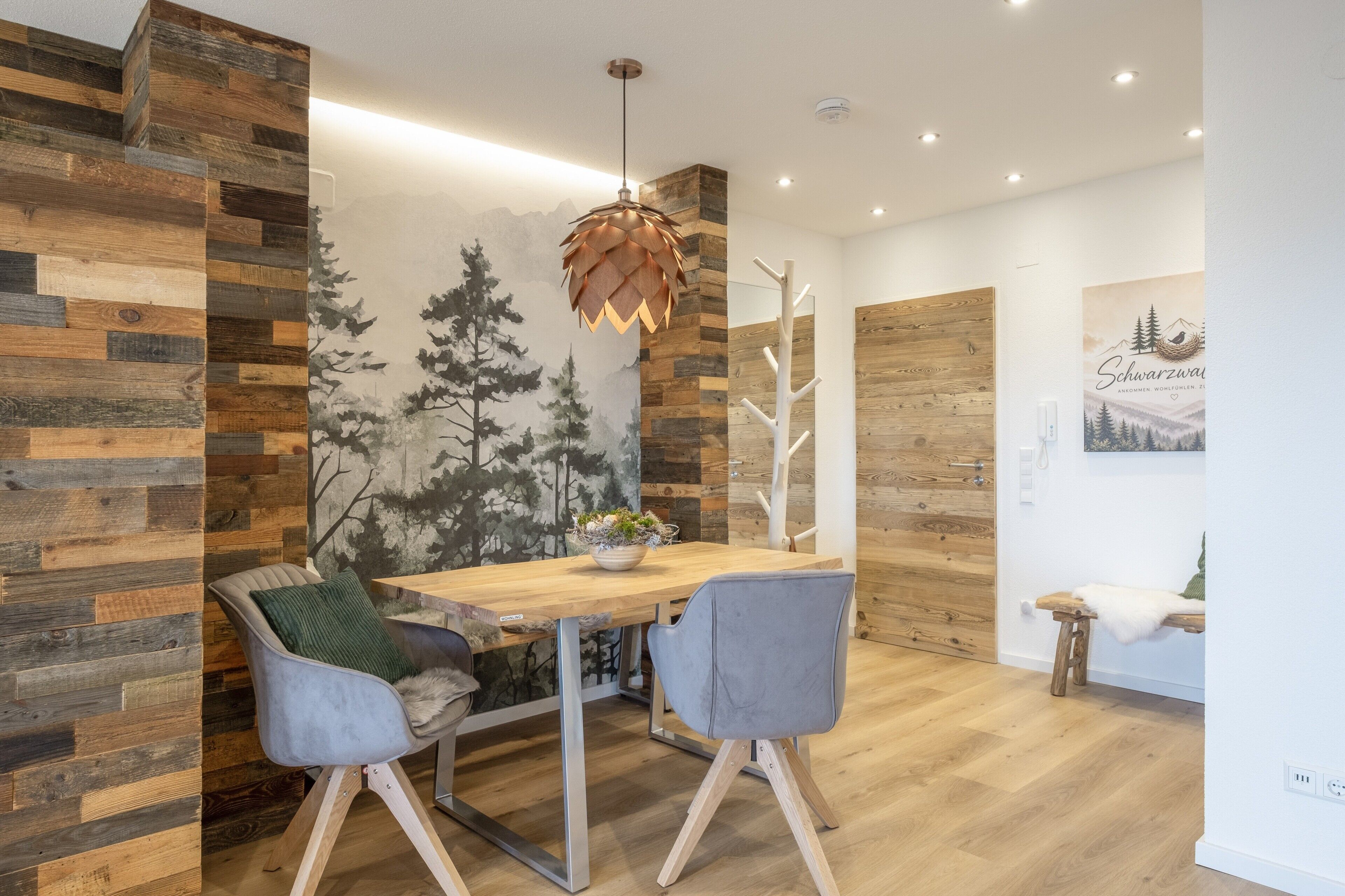 Ein stilvoller Essbereich mit einem Holztisch, zwei Stühlen und einer Wandmalerei.