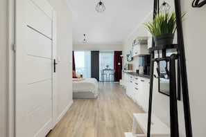 A modern apartment with a kitchen, dining area, and a bedroom. - Funkcjonalne Studio z Klimatyzacja i Miejscem do Pracy by Noclegi Renters (Katowice)