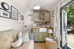 A cozy room with a sofa, a small table, a basket, and a window with curtains.