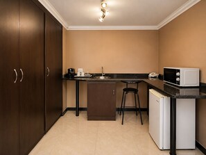 A compact kitchen with a sink, a microwave, and a coffee maker.