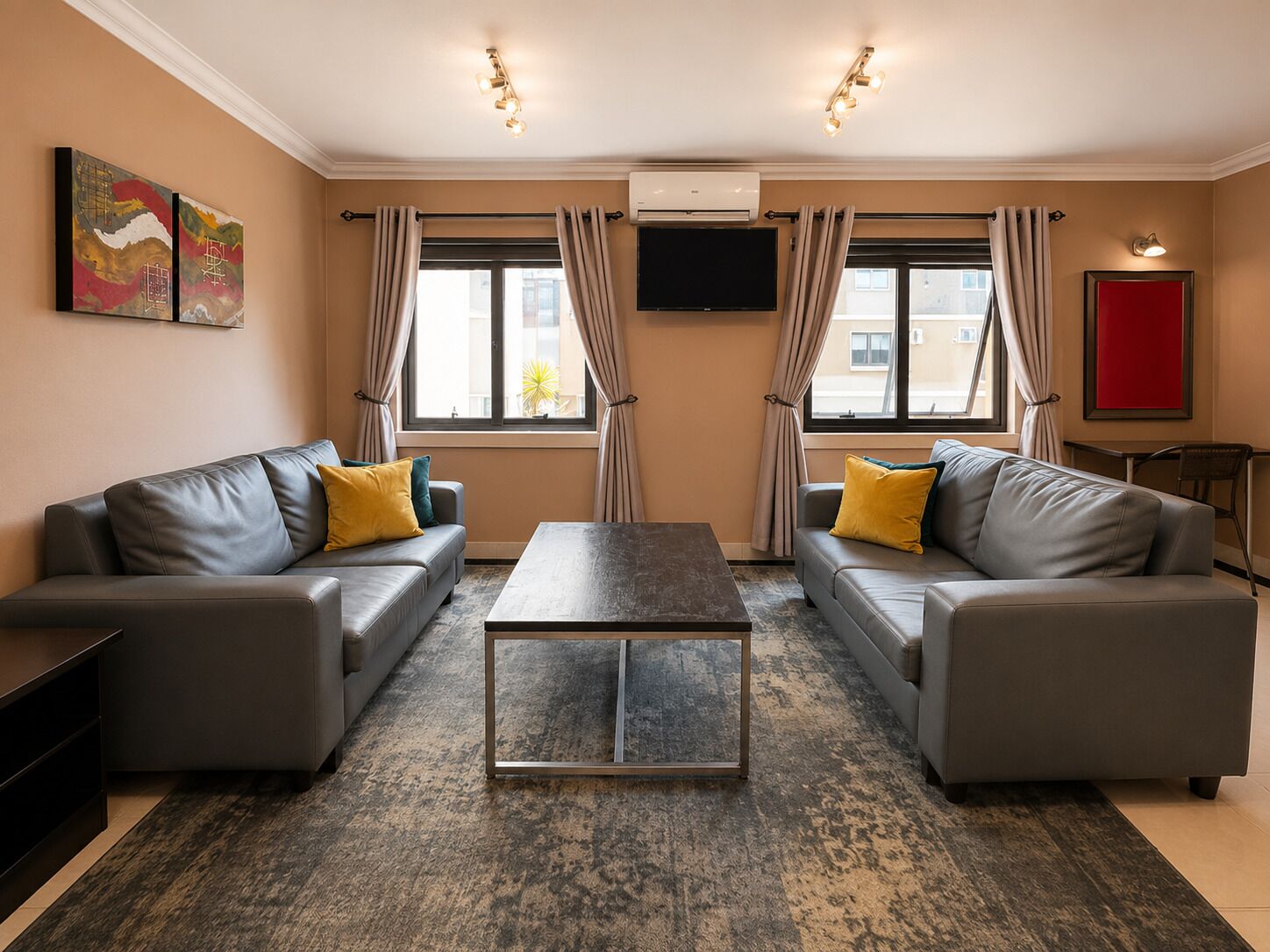 Een moderne woonkamer met twee banken, een salontafel en een flatscreen televisie.