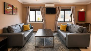 Een moderne woonkamer met twee banken, een salontafel en een flatscreen televisie.