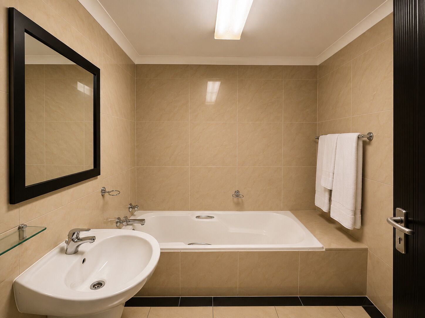 Un baño con bañera, lavamanos y espejo.