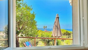 A kitchen with a view of a balcony, a kettle, a toaster, and a table. - One-bedroom apartment in Rupione with exceptional ocean views, a 6-minute walk from the beach (Pietrosella)