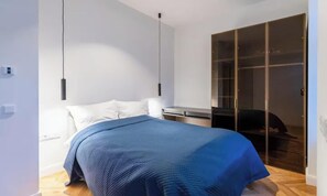 Ein Schlafzimmer mit einem Bett, einem Kleiderschrank und einem Schreibtisch.