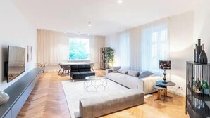 Ett modernt vardagsrum med en soffa, ett soffbord, en tv och en matplats med ett bord och stolar.
