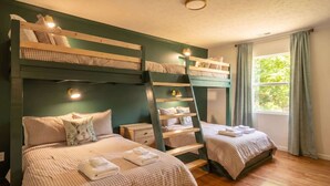 A room with bunk beds, a ladder, a window with curtains, and a nightstand with a lamp. - Weekend Vibes - 1 Level - Pool - Hot Tub - Fenced Yard (Sevierville)