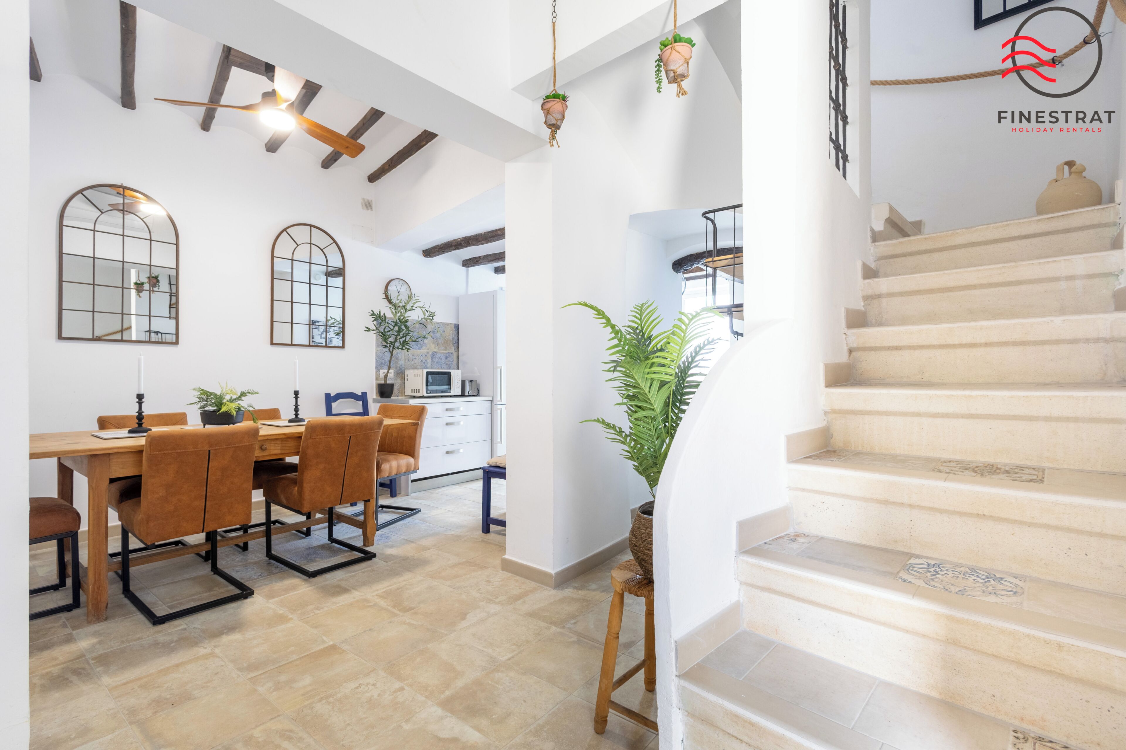 A modern interior with a dining area, kitchen, and staircase.
