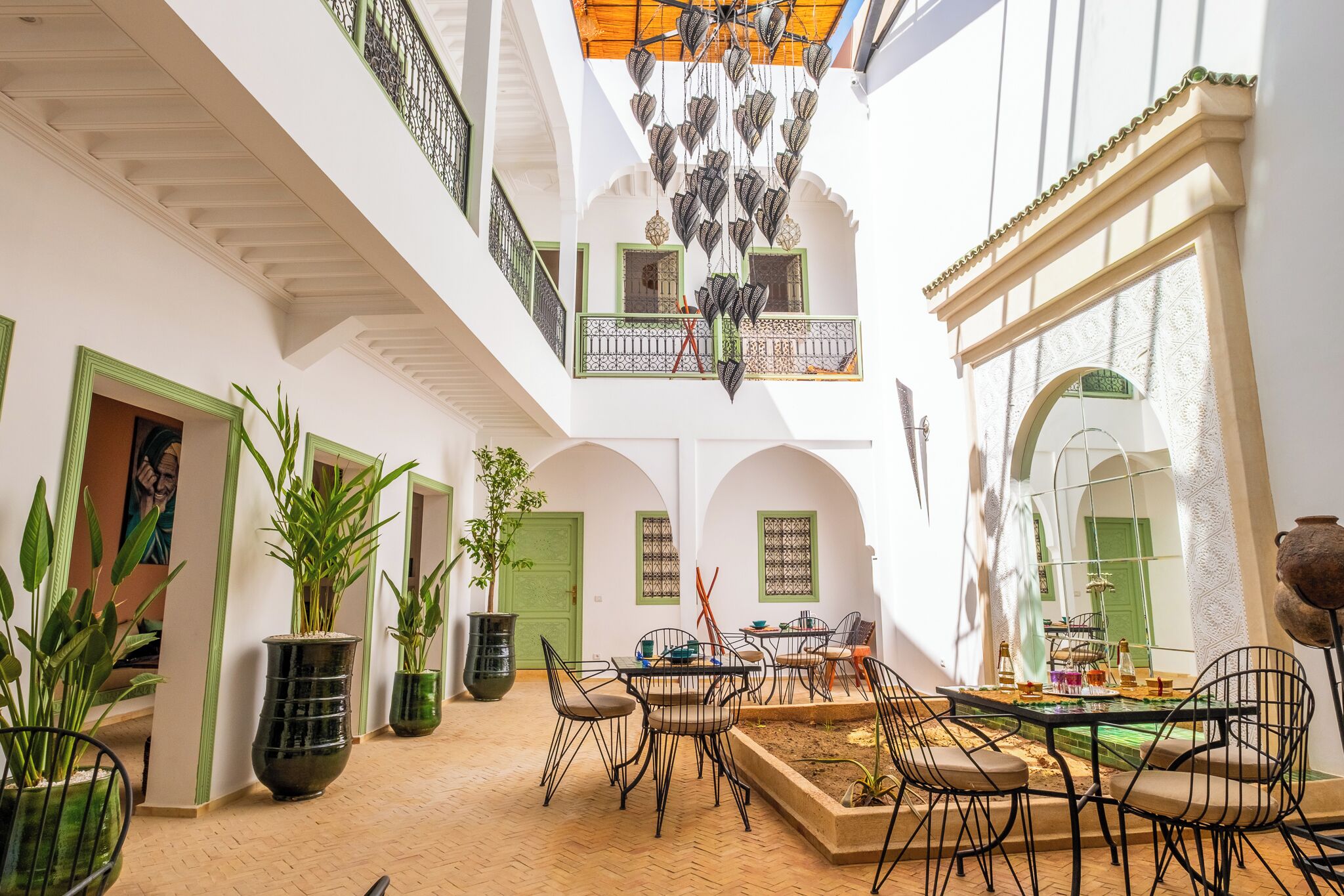 Un amplio patio con zona de comedor, plantas en macetas y vistas a la arquitectura circundante.