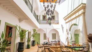 Ein geräumiger Innenhof mit Essbereich, Kübelpflanzen und Blick auf die umliegende Architektur.