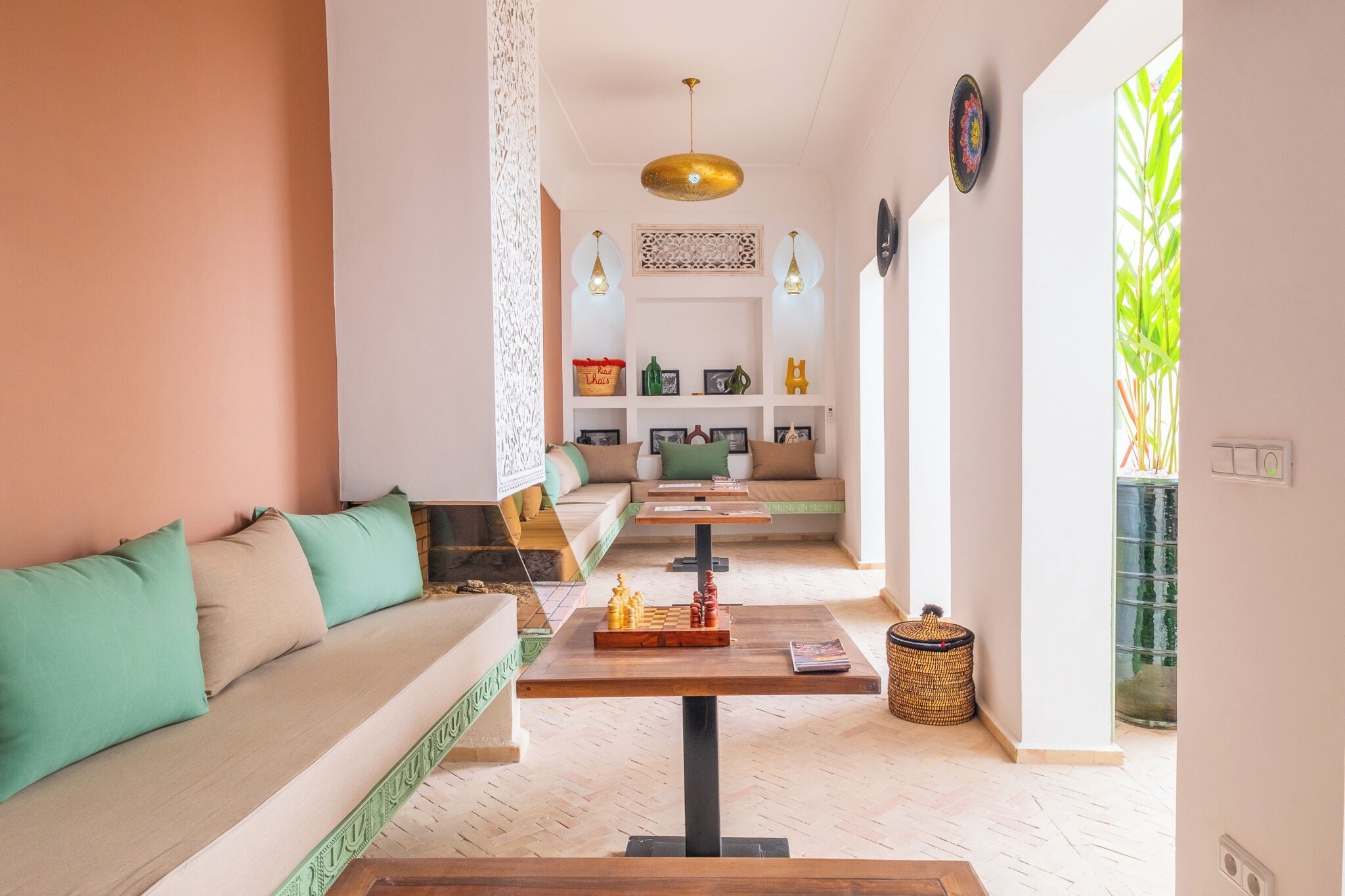 A modern living room with a sofa, a coffee table with a chessboard, and a decorative wall panel.