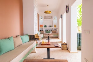 Una sala de estar moderna con un sofá, una mesa de centro con un tablero de ajedrez y un panel decorativo en la pared.