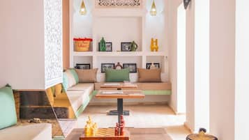 Uma sala de estar aconchegante com um sofá, uma mesa de centro e um tabuleiro de xadrez.