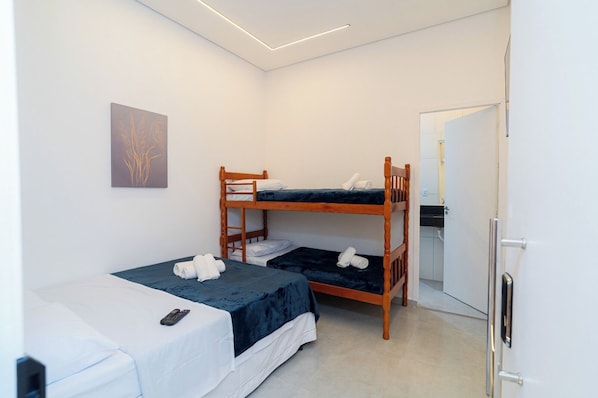 A room with bunk beds, a desk, and a door.