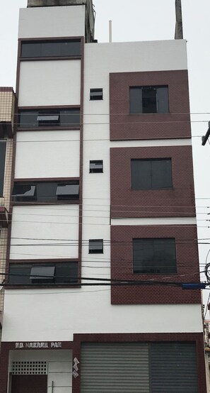 A multi-story building with a white facade and red brick accents. - 206 Versátil e Aconchegante (Belém)