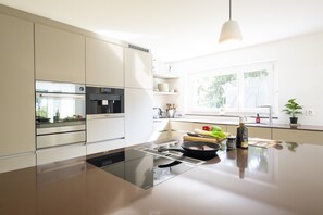 Uma cozinha moderna com eletrodomésticos integrados, uma ilha central e uma janela que proporciona luz natural.