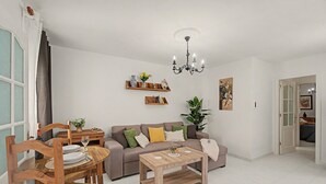 Un salon comprenant un canapé, une table basse et un coin repas avec des chaises et une table.