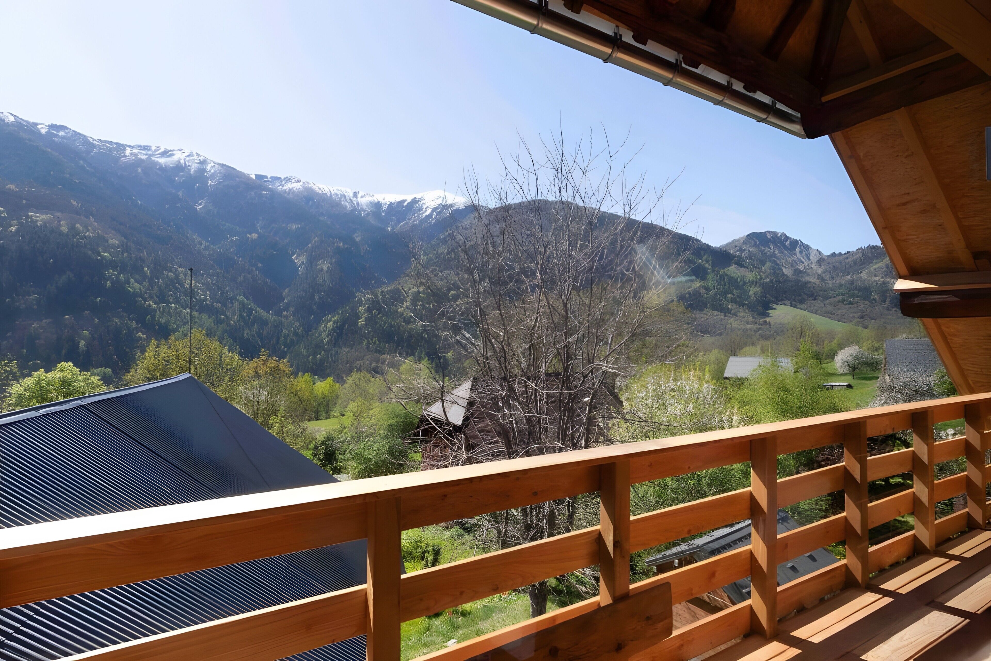 A wooden balcony with a view of a mountainous landscape.